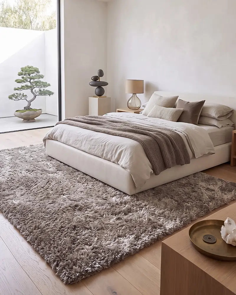 Een beige vloerkleed met een zachte hoogpolige structuur in de slaapkamer.