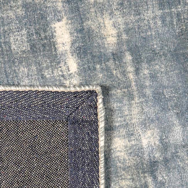 Achterkant hoek aanzicht van het vloerkleed AURALIS in de kleur Grijs, gemaakt van Viscose.