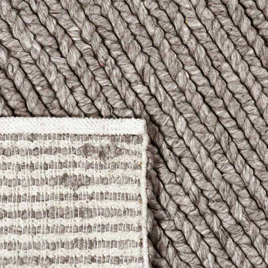 Achterkant hoek aanzicht van het vloerkleed HAYLOR in de kleur Grijs, gemaakt van 100% Wol.