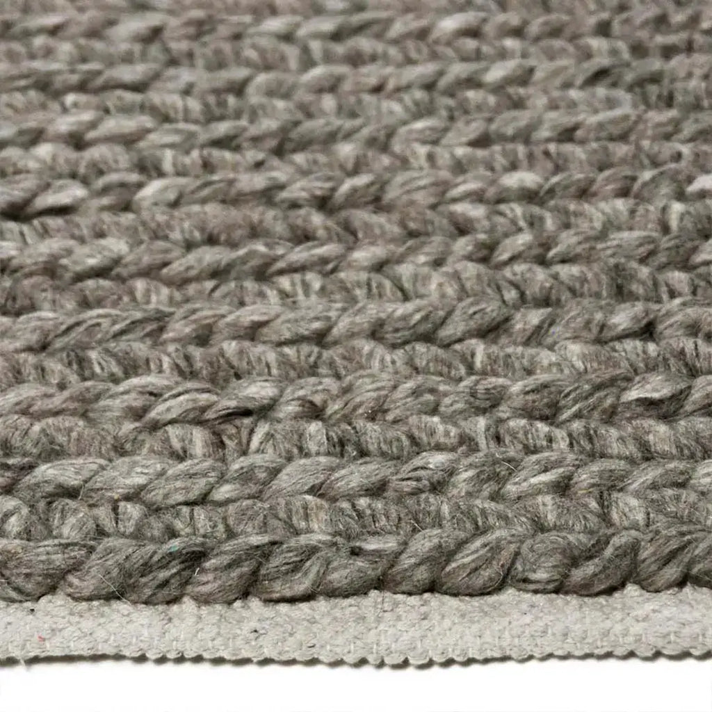 Zijkant detail aanzicht van het vloerkleed HAYLOR in de kleur Grijs, gemaakt van 100% Wol.
