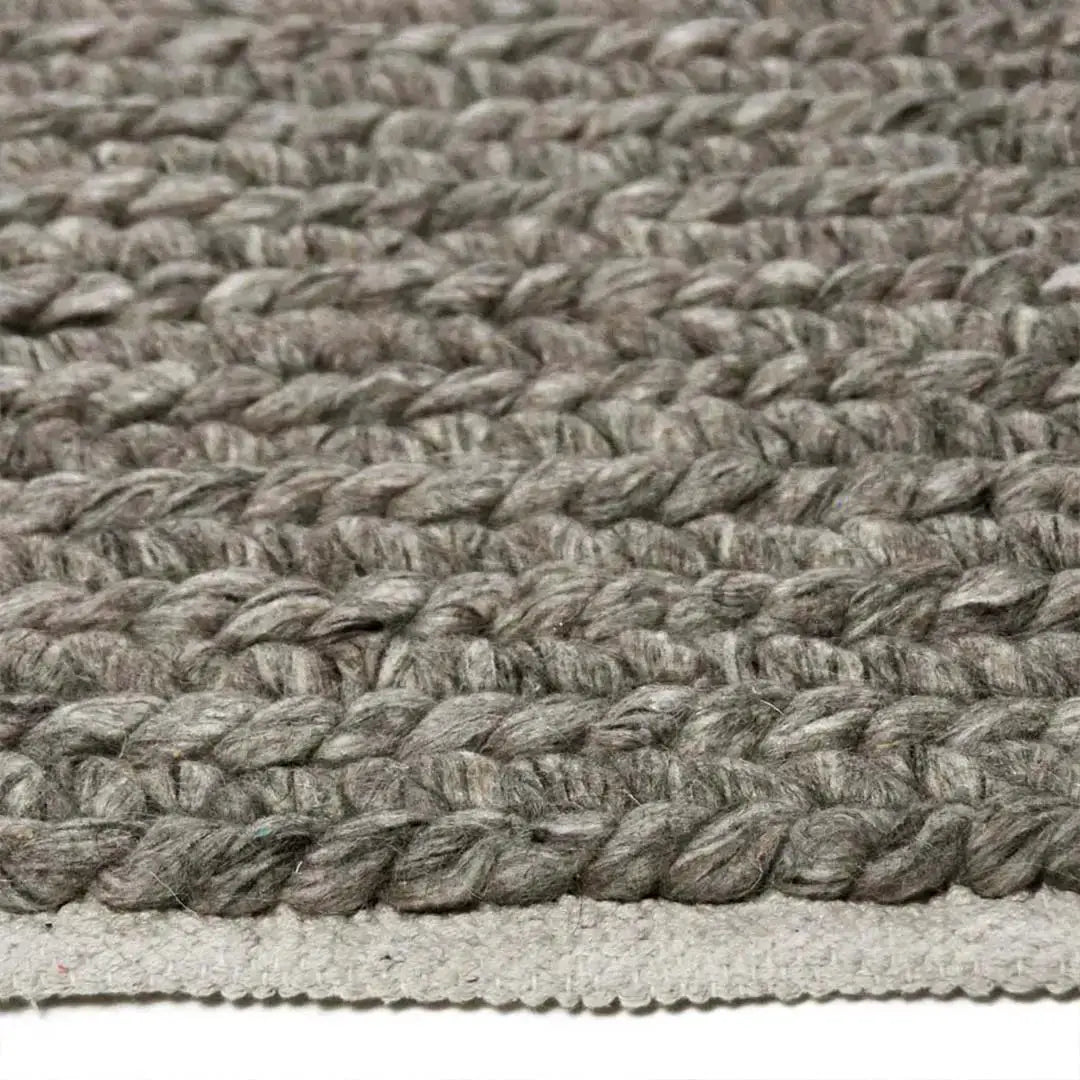 Zijkant detail aanzicht van het vloerkleed HAYLOR in de kleur Grijs, gemaakt van 100% Wol.
