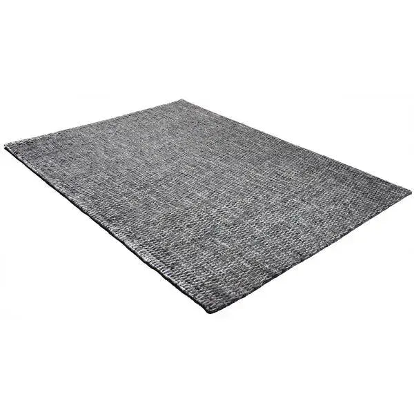 Diagonaal aanzicht van het vloerkleed HUXLEY in de kleur Denim Blauw, gemaakt van Wol en Viscose mix.