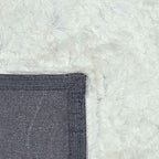 Achterkant hoek aanzicht van het vloerkleed INDIRA in de kleur Wit, gemaakt van Polyester.