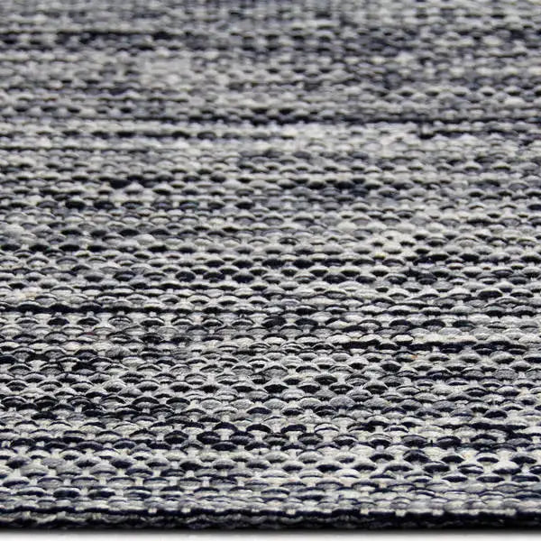Zijkant detail aanzicht van het vloerkleed LYDEN in de kleur Zwart, gemaakt van Katoen.
