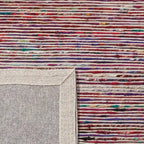 Achterkant hoek aanzicht van het vloerkleed MERRIN in de kleuren Blauw / Rood, gemaakt van Recycled Sari Zijde.
