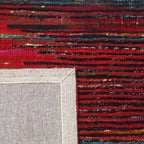 Diagonaal aanzicht van het vloerkleed MERRIN in de kleuren Rood / Zwart, gemaakt van Recycled Sari Zijde.