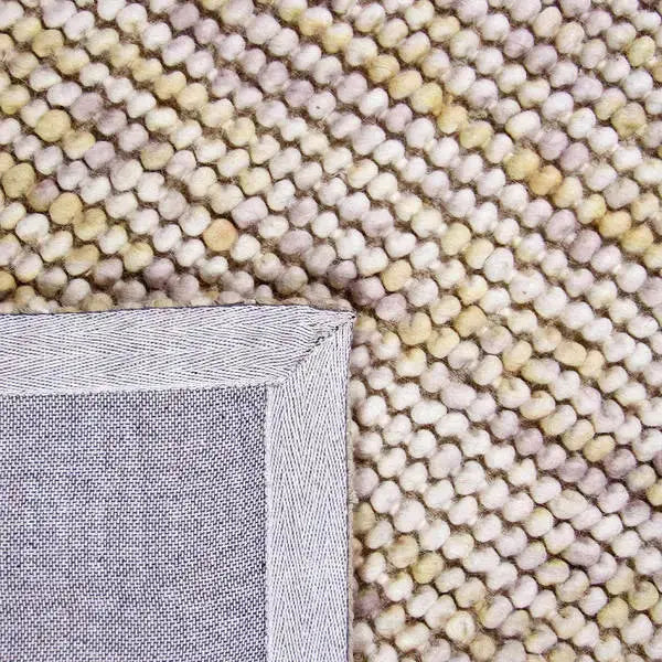 Achterkant hoek aanzicht van het vloerkleed MIRANDE in de kleuren Beige / Bruin, gemaakt van 100% wol.