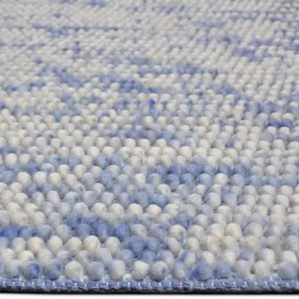 Zijkant detail aanzicht van het vloerkleed MIRANDE in de kleuren Licht Blauw / Beige, gemaakt van 100% Wol.