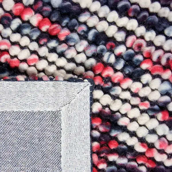 Achterkant hoek aanzicht van het vloerkleed MIRANDE in de kleuren Rood / Zwart, gemaakt van 100% Wol.