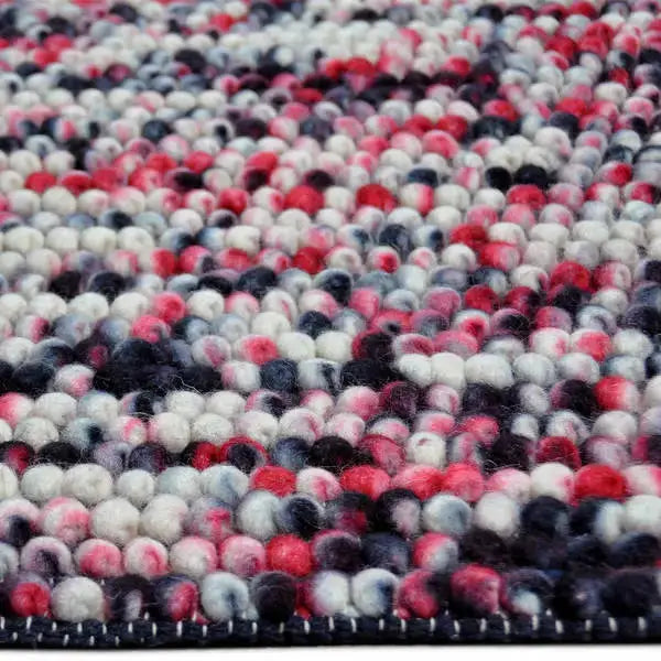 Zijkant detail aanzicht van het vloerkleed MIRANDE in de kleuren Rood / Zwart, gemaakt van 100% Wol.