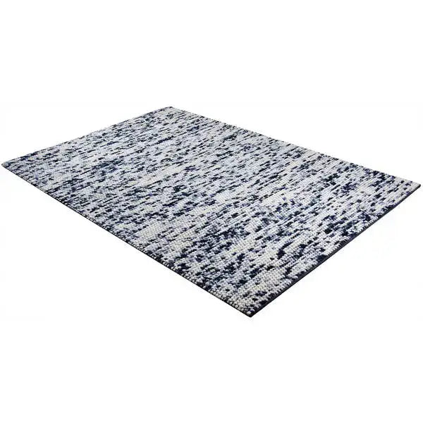 Diagonaal aanzicht van het vloerkleed MIRANDE in de kleuren Zwart / Beige, gemaakt van 100% Wol.