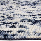 Zijkant detail aanzicht van het vloerkleed MIRANDE in de kleuren Zwart / Beige, gemaakt van 100% Wol.