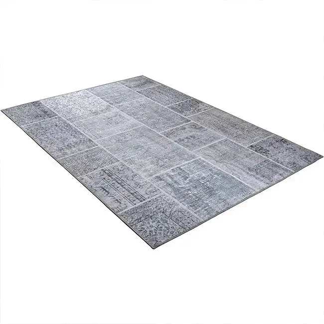 Diagonaal aanzicht van het vloerkleed NEXON patch in de kleur Grijs, gemaakt van Polyester.