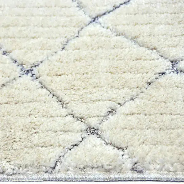 Zijkant detail aanzicht van het vloerkleed OLMAR in de kleuren Wit / Licht Grijs, gemaakt van Polyester.
