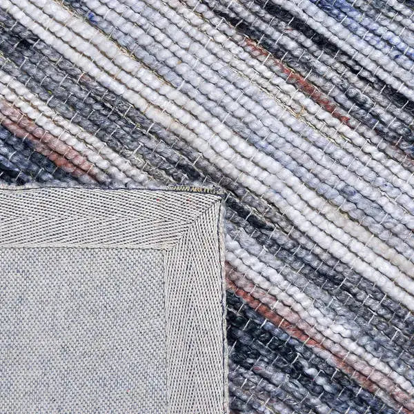 Achterkant hoek aanzicht van het vloerkleed ONYR in de kleuren Naturel / Grijs, gemaakt van Wol en Viscose mix.