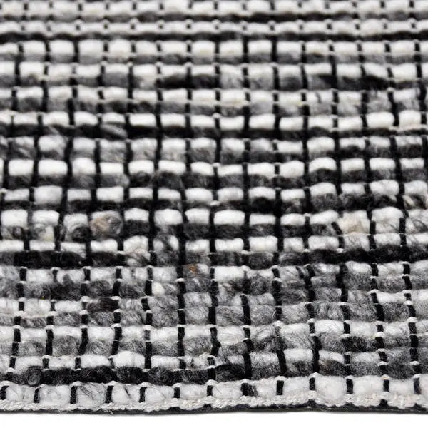 Zijkant detail aanzicht van het vloerkleed QUORIN in de kleur Antraciet, gemaakt van 100% Wol.
