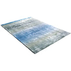 Diagonaal aanzicht van het vloerkleed RUVEN in de kleuren Groen / Blauw, gemaakt van Viscose.