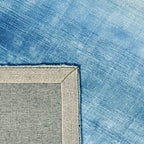 Achterkant hoek aanzicht van het vloerkleed RUVEN in de kleur Turquoise, gemaakt van Viscose.
