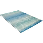 Diagonaal aanzicht van het vloerkleed RUVEN in de kleur Turquoise, gemaakt van Viscose.