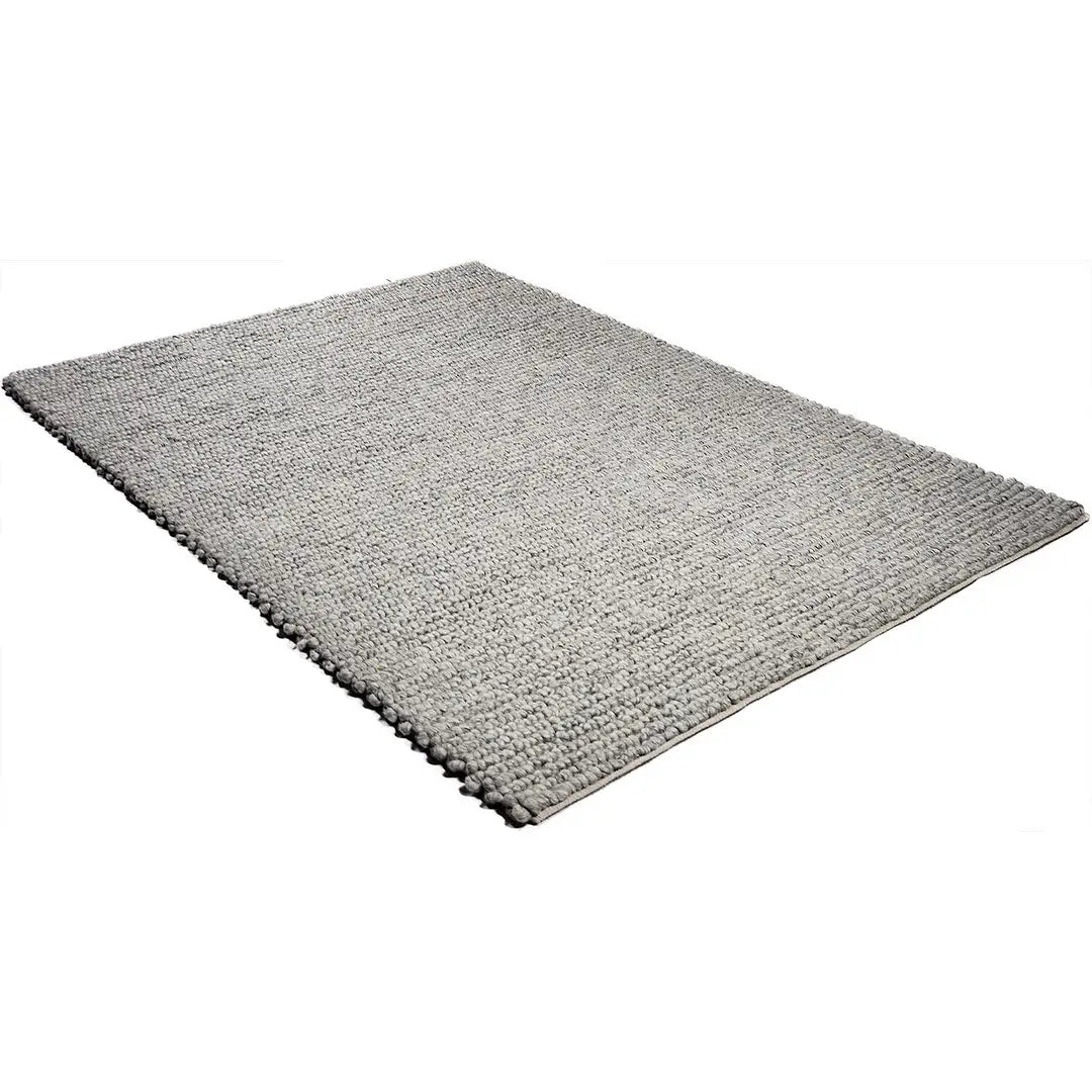 Diagonaal aanzicht van het vloerkleed SAVONA in de kleur BT Grijs, gemaakt van 100% Wol.