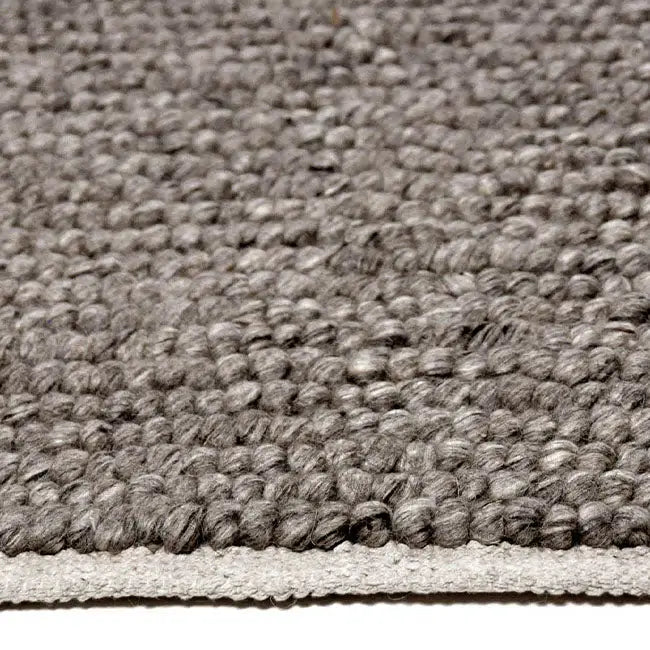 Zijkant detail aanzicht van het vloerkleed SAVONA in de kleur Grijs, gemaakt van 100% Wol.
