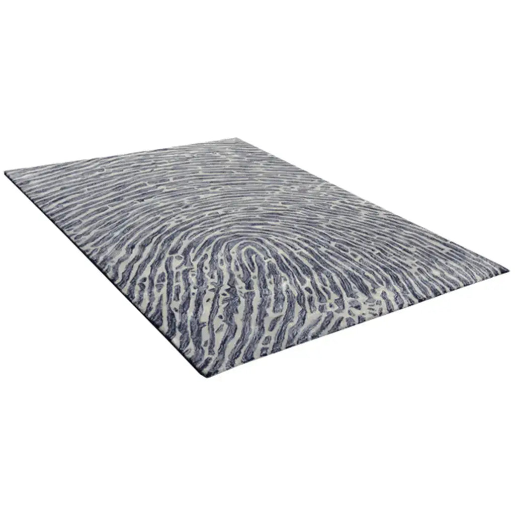 Diagonaal aanzicht van het vloerkleed TALRON UP in de kleur Grijs, gemaakt van Wol en Viscose mix.