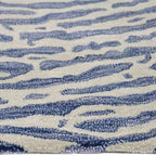 Zijkant detail aanzicht van het vloerkleed TALRON UP ovaal in de kleur Blauw, gemaakt van Wol en Viscose mix.
