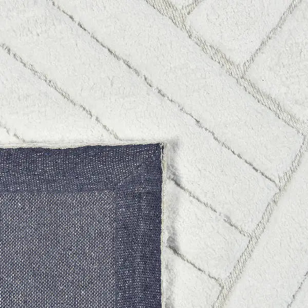 Achterkant hoek aanzicht van het vloerkleed TYRON in de kleur Wit, gemaakt van Polyester.