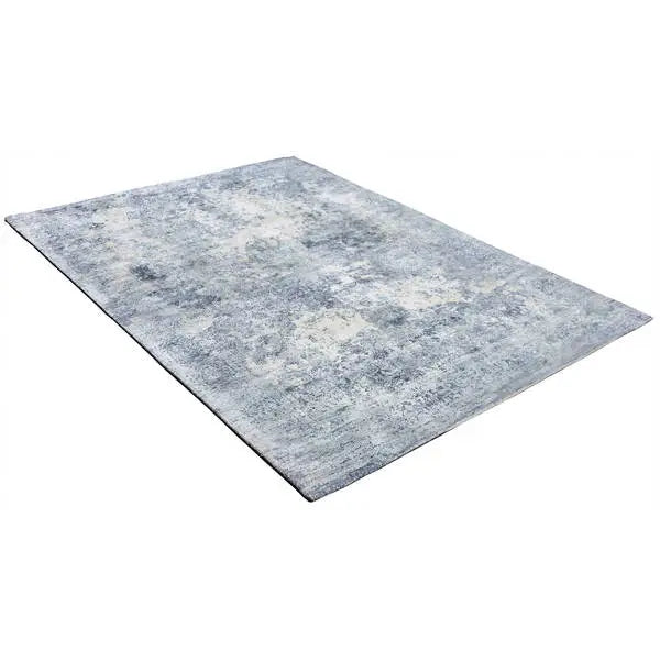 Diagonaal aanzicht van het vloerkleed VALCERA modern in de kleur Blauw, gemaakt van Viscose.